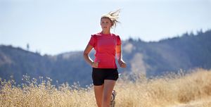 A female jogging down a dirt road.