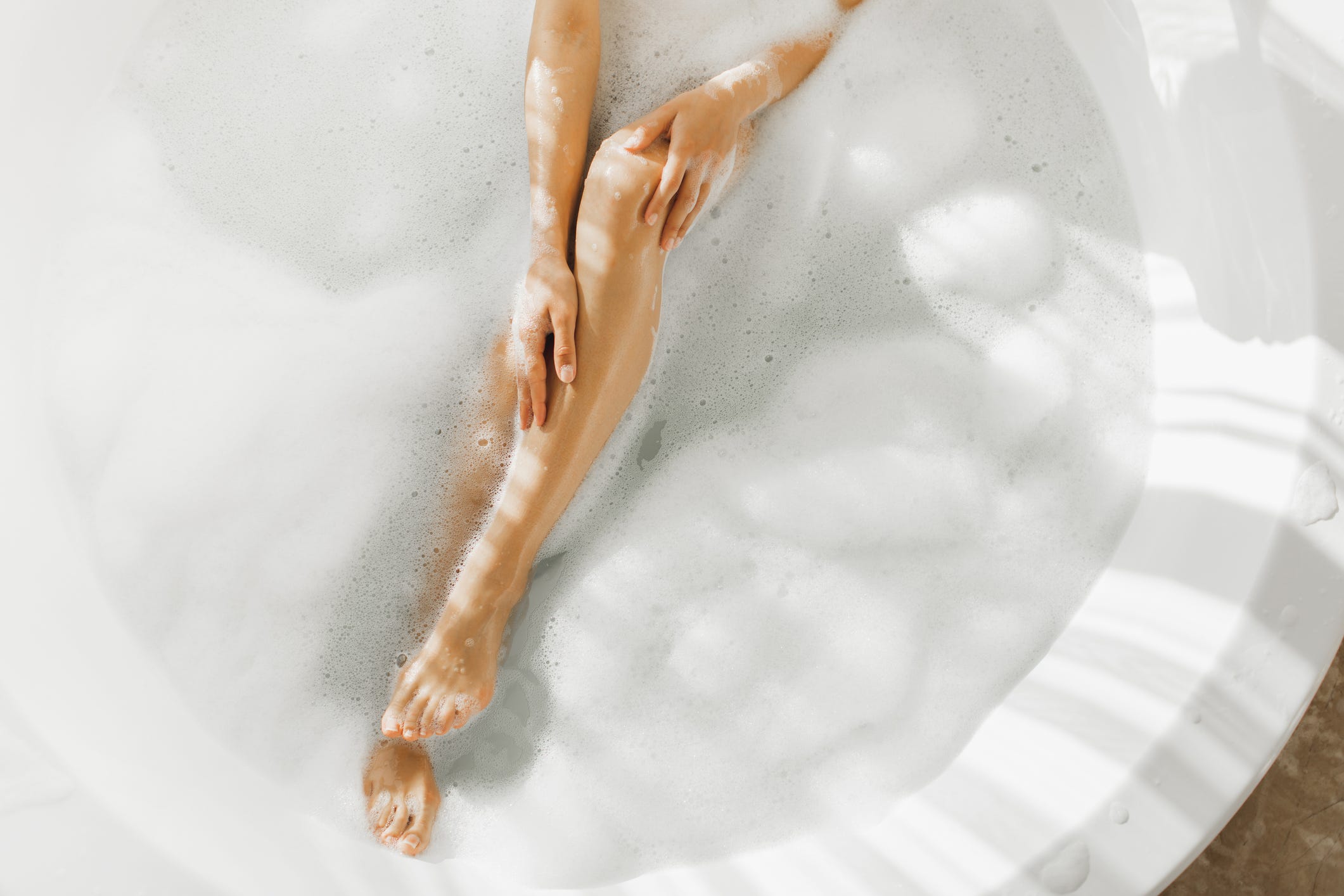 female legs in foam bubble bath