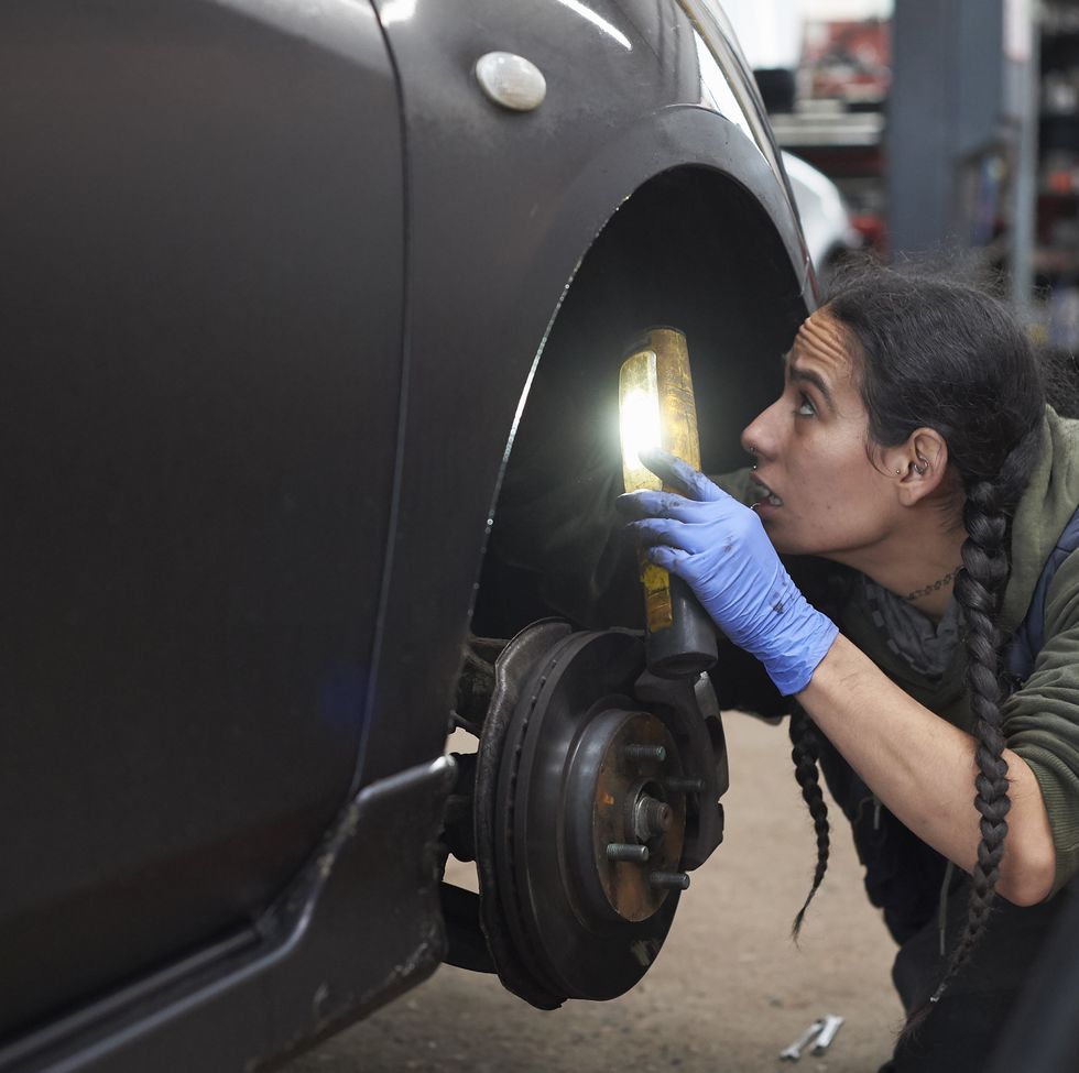 a female mechanic at work on a car
