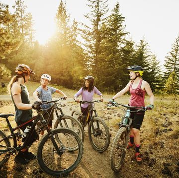 female mountain bikers in discussion after descending mountain trail