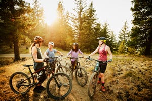 female mountain bikers in discussion after descending mountain trail