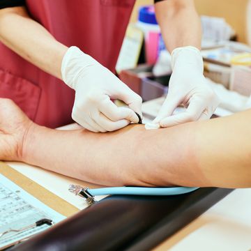 female nurse collects blood from senior patient for testing at hospital
