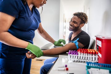 female nurse drawing blood sample from young man in medical office