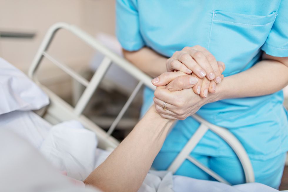enfermera cogiendo la mano de una mujer mayor