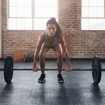 Female performing deadlift exercise with weight bar