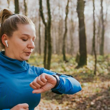 female runner checking smartwatch while running