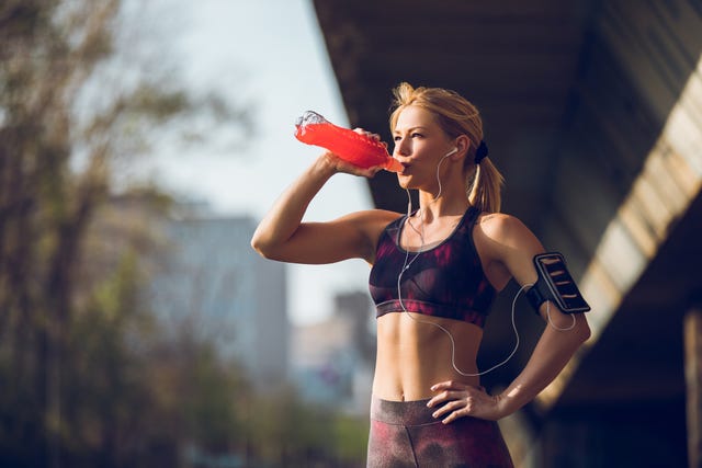 female runner having break and drinking refreshment drink