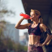 female runner having break and drinking refreshment drink