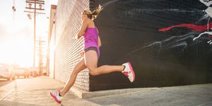 female runner running along sidewalk