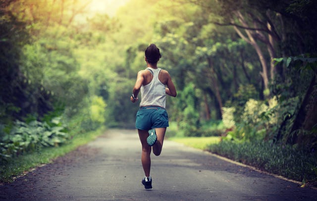 female runner running at summer park trail  healthy fitness woman jogging outdoors