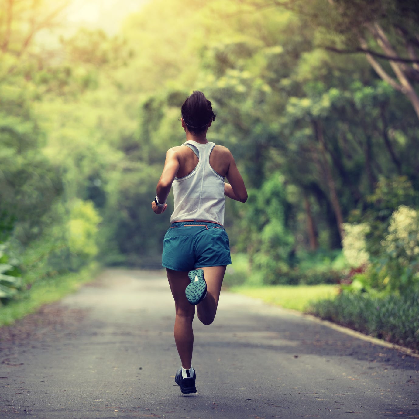 female runner running at summer park trail  healthy fitness woman jogging outdoors