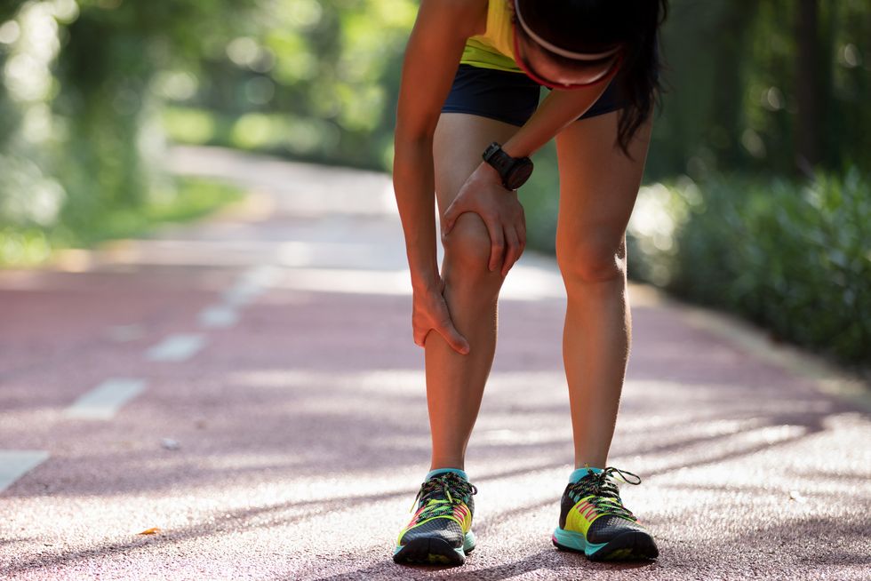 female runner suffering with pain on sports running knee injury