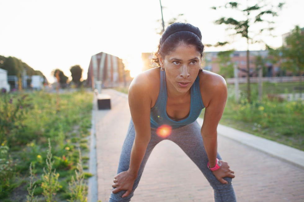 female runner taking a break on sidewalk