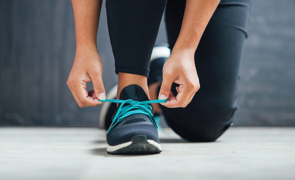 Female runner tying her shoes preparing for a run