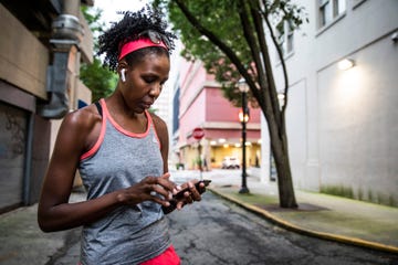 female runner using mobile device in urban area