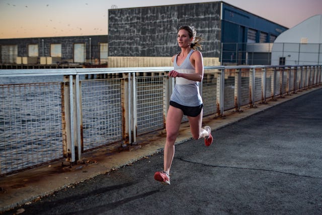 Female running along waterfront at twilight