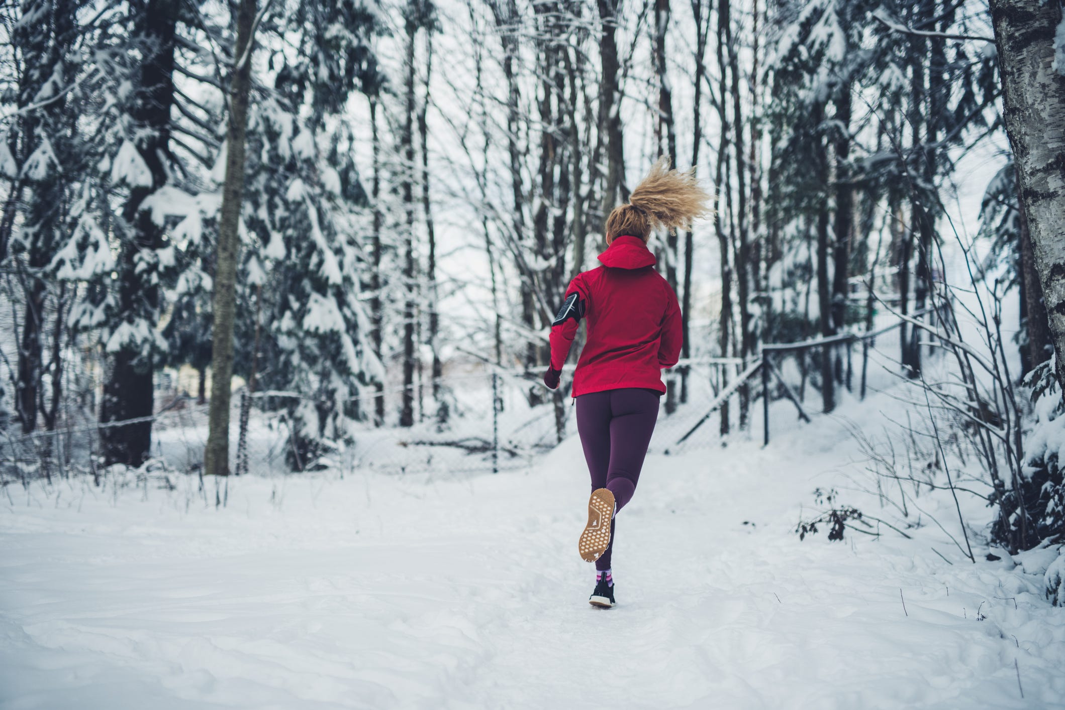 female running in forest at winter day