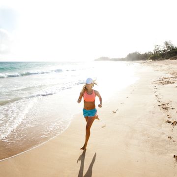 female running on a sandy beach.