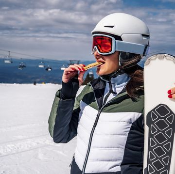 female skier eating snack during skiing pause