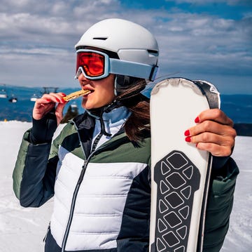 female skier eating snack during skiing pause