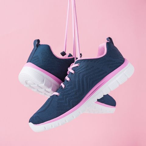 female sneakers for run on a pink background fashion stylish sport shoes, close up