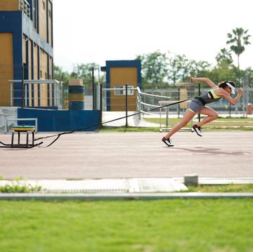 female sprinter pulling a weighted sled for speed
