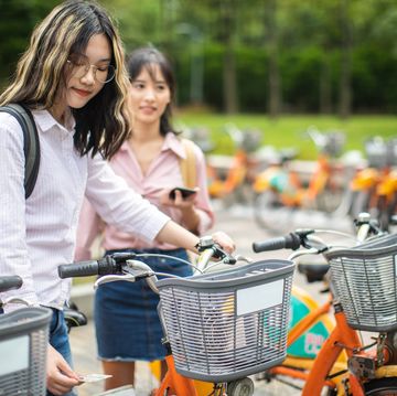 female students with backpacks renting a bike in taipei