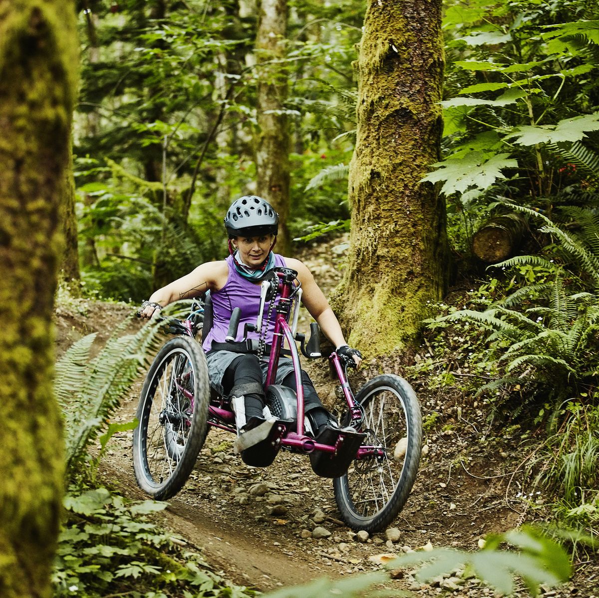 female wheelchair athlete descending trail on adaptive mountain bike