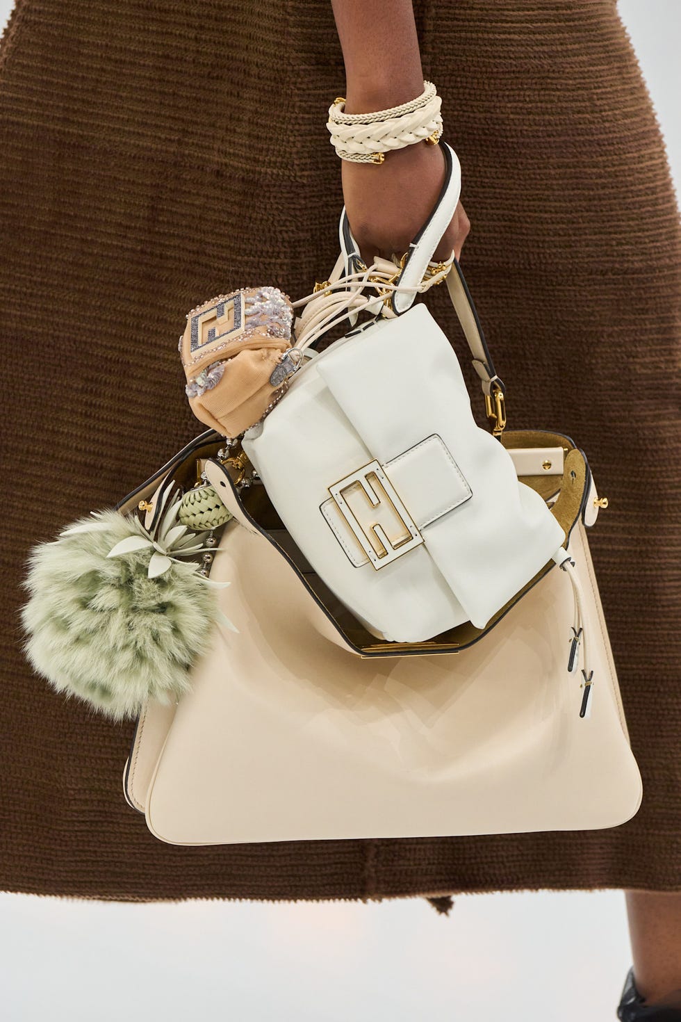 Fashionable handbag held by a model showing various textures and colors