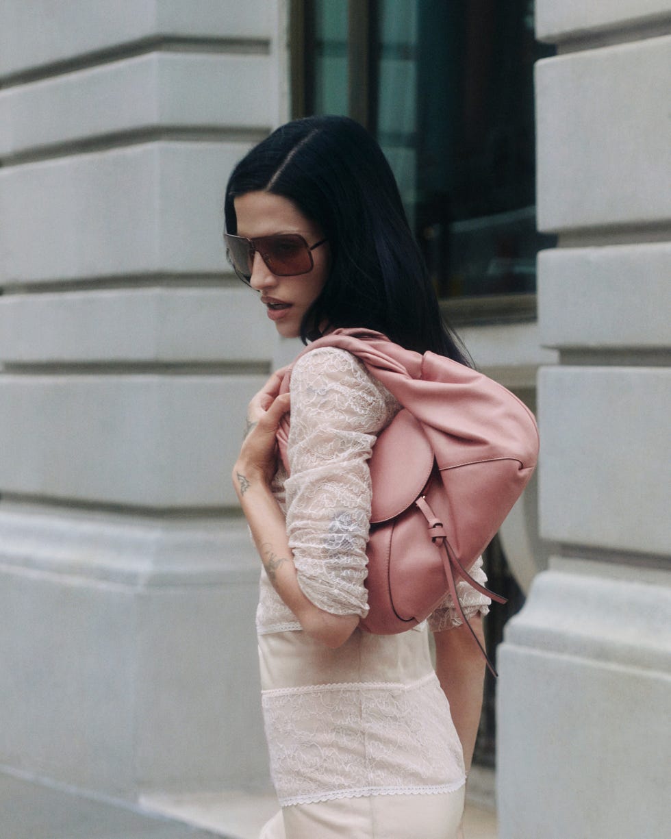 woman carrying a pink backpack in an outdoor urban setting