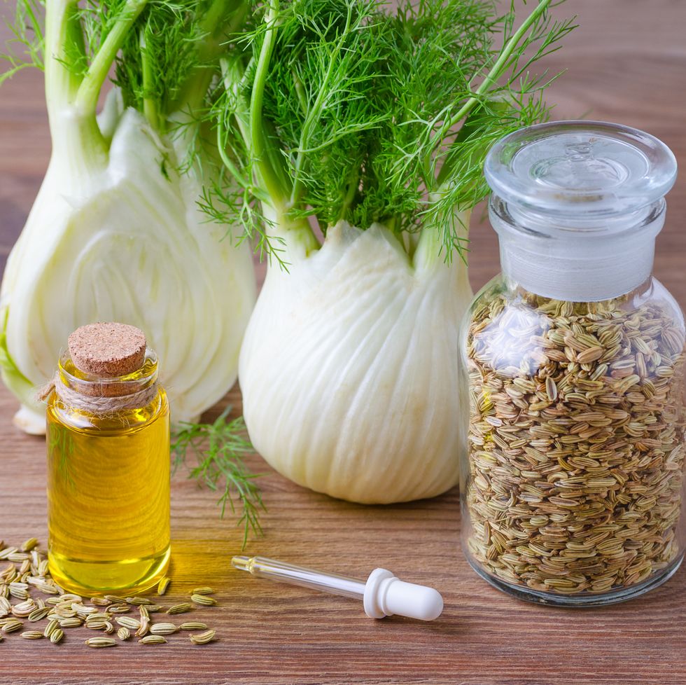 fennel essential oil, bulb and seeds, a pipette selective focus on wooden