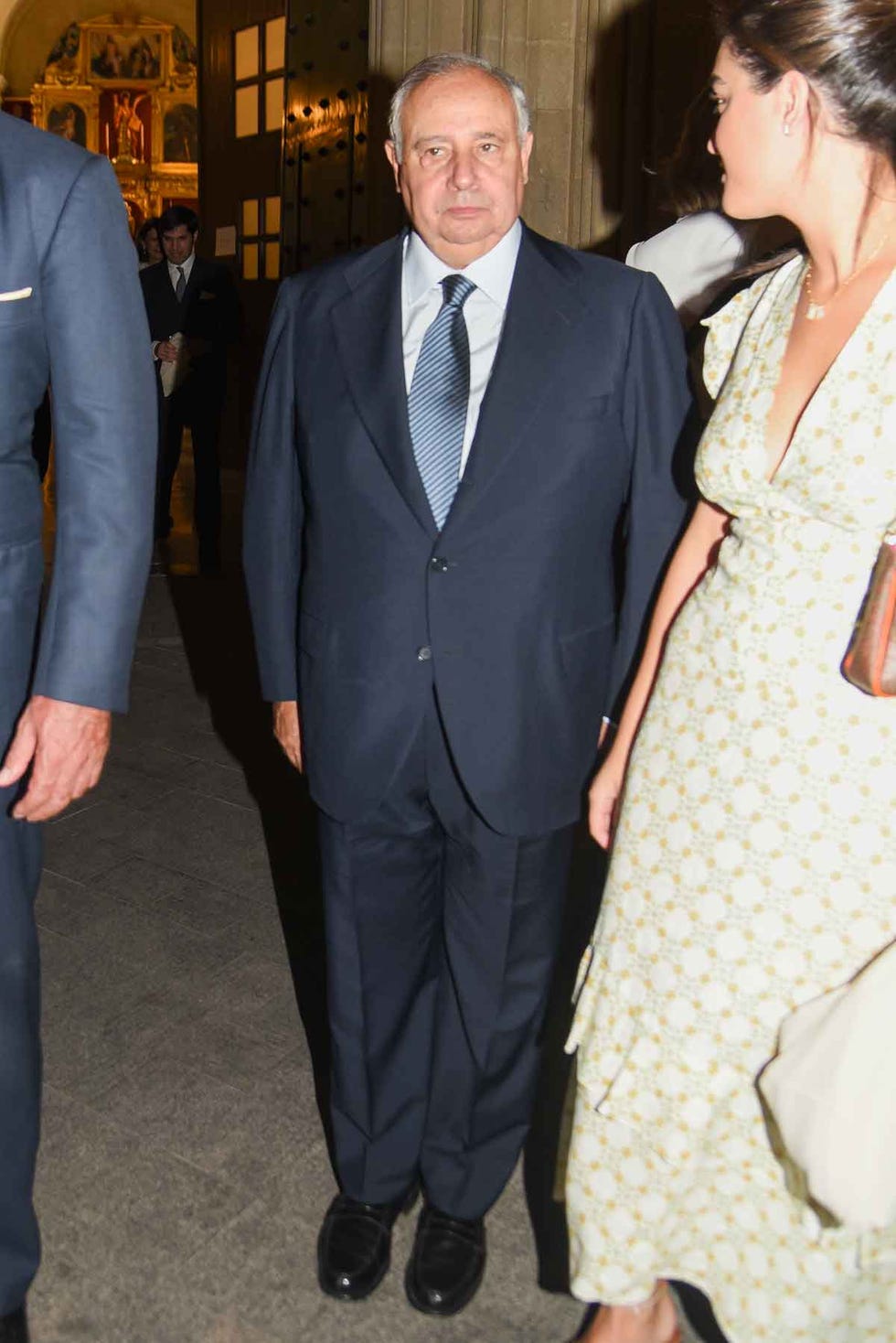 a man in a suit and tie walking with a woman in a dress