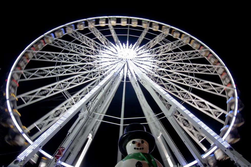ferris wheel and snowman in amusement park at night