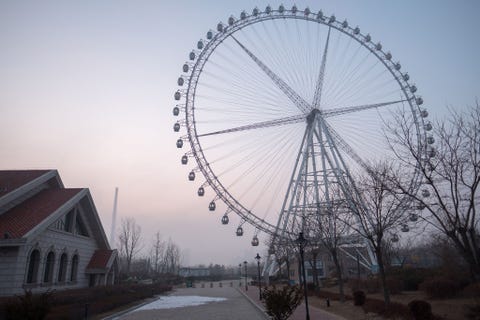 Een leeg reuzenrad torent uit boven een woonwijk in Dandong China
