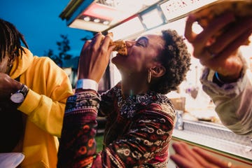 a young women enjoying pizza with friends at a music festival