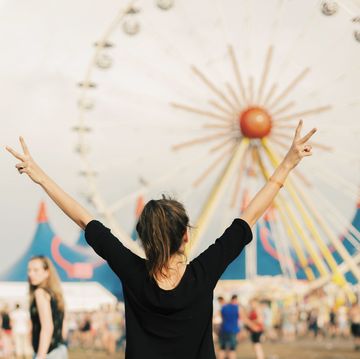meisje met armen in de lucht op een festivalterrein