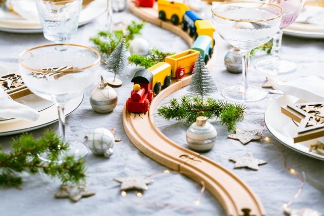 festive christmas place setting with small wooden railway