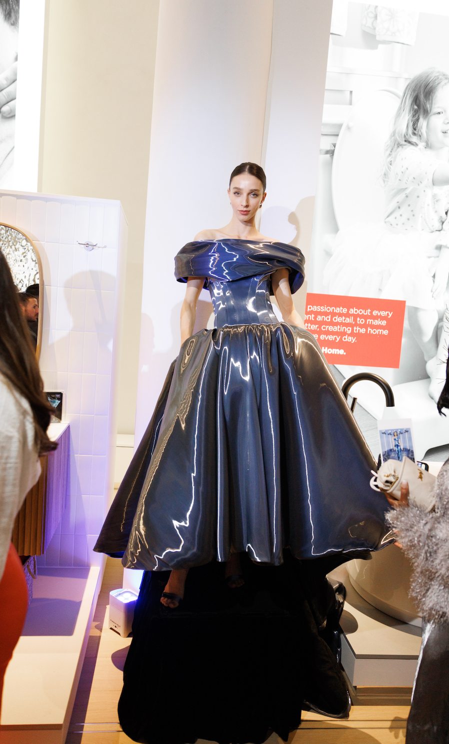 Showcase of a shiny blue gown on a mannequin in a modern setting.