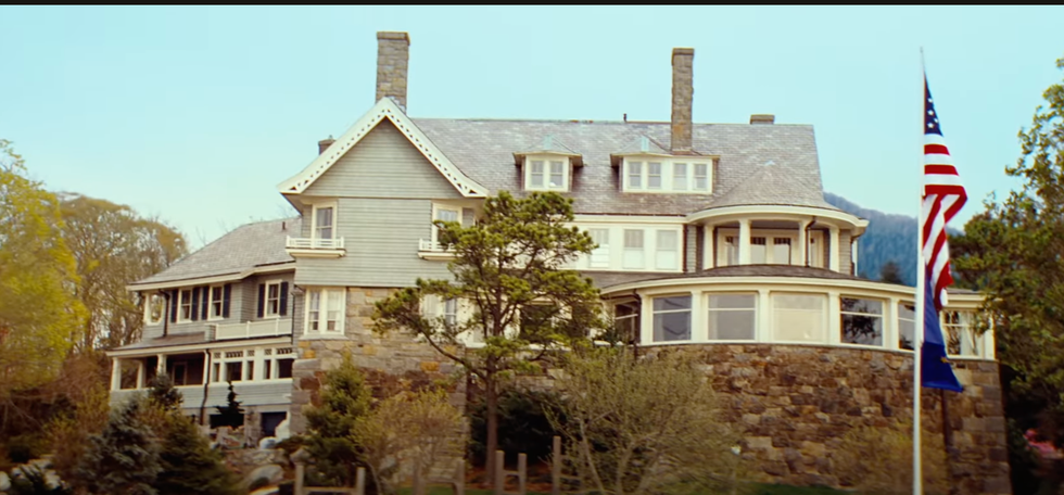 Historic house with stone foundation and flagpole.