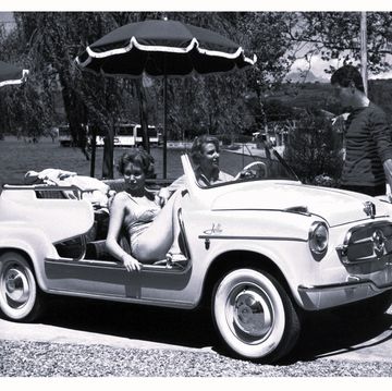 a man and a woman in a convertible car
