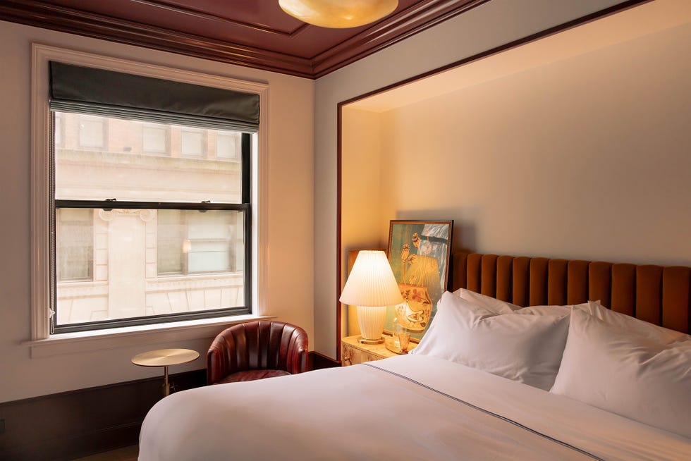 cozy bedroom with a large window a plush bed and a reading area