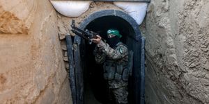 a fighter from izz al din al qassam stands in front of a