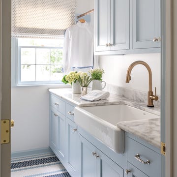 a laundry room white light blue cabinets