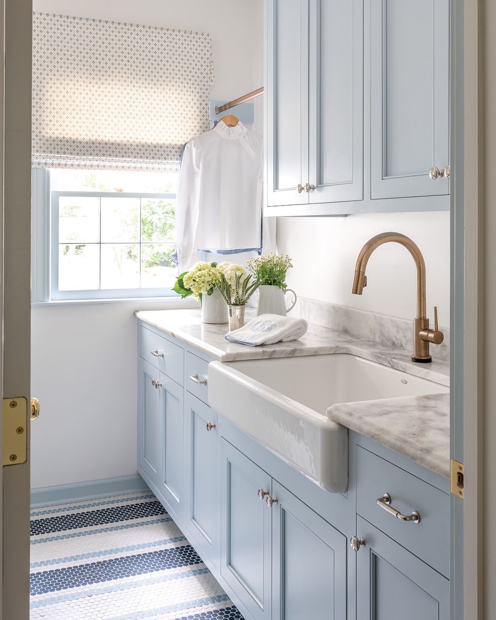 a laundry room white light blue cabinets