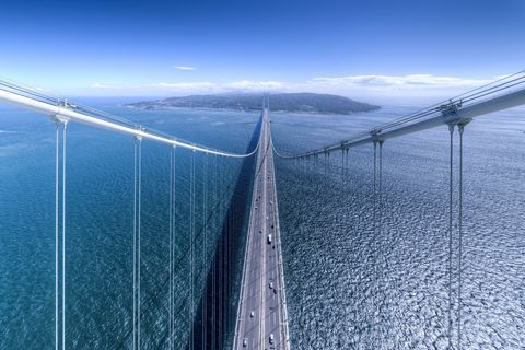 De AkashiKaikyobrug verbindt Awaji Island met Honshu het grootste Japanse eiland De brug is bijna vier kilometer lang en brengt dagelijks ongeveer 23000 autos naar de overkant