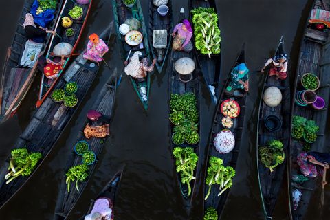 Op de drijvende markt van Lok Baintan in Indonesi komen maar liefst honderd boten samen vr zonsopgang zoals ze al vijfhonderd jaar doen Terwijl de boten over de rivier drijven verhandelen de vrouwen producten zoals vers fruit groenten gebak en vlees