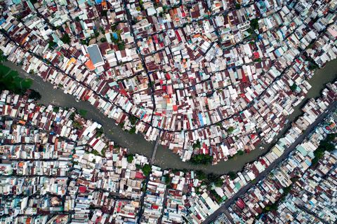 Van bovenaf ziet deze wijk in Ho Chi MinhStad Vietnam er vrolijk en vredig uit Maar beneden is het een ander verhaal zegt Your Shotfotograaf Tan Diep Bao Het gebied Black Water Hamlet werd oorspronkelijk bewoond door immigranten die stalhuizen op de grachten hebben gebouwd Het is nu een sloppenwijk met een extreem slechte omgeving geworden zegt Tan Diep Bao Deze kanalen worden steeds meer verontreinigd met afval
