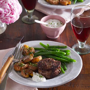 filet mignon with duck fat potatoes and green beans, with horseradish sauce on the side and a glass of red wine