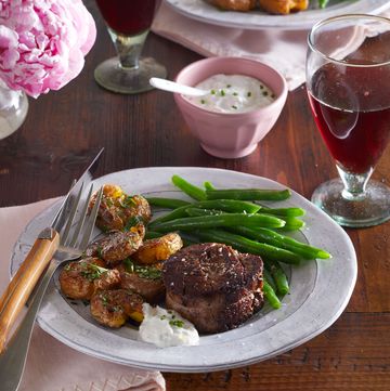 filet mignon with duck fat potatoes and green beans, with horseradish sauce on the side and a glass of red wine