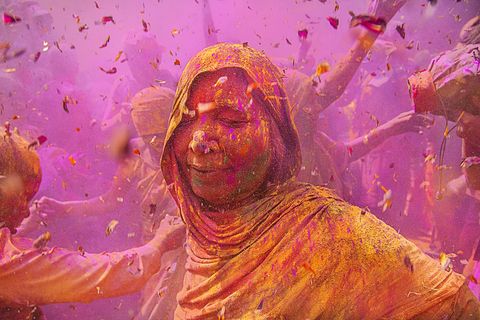 Op een Holifestival in India geniet een vrouw van het kleurrijke feest Holi is een jaarlijks Hindoestaans festival dat het einde van de winter en de komst van de lente viert Deelnemers zingen dansen delen snoep uit en besproeien elkaar met water en gekleurd poeder
